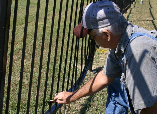 Gentleman painting a fence